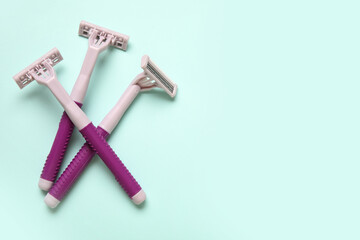 Disposable shaving razors on turquoise background, closeup
