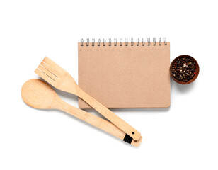 Blank recipe book with spatulas and spices on white background