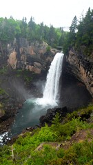 Obraz premium Scenic Waterfall in a Verdant, Rocky Canyon