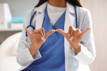 Female doctor using sign language in clinic, closeup © Pixel-Shot