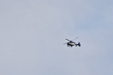 Helicopter of the Dutch national police force flying in the sky, seen from the ground