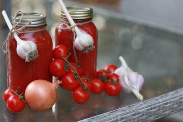 Tomato sauce, in jars on a white background, on the table, spices, twists for the winter
