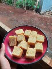 Sweet baked bread fresh from the oven looks tempting with its even golden color. Its fragrant aroma wafts through, whetting your appetite. Served warm on a white plate.