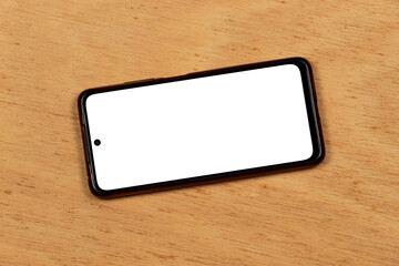 a smartphone with a white color display over an orange wooden background