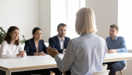 Obraz premium Business meeting with a team of five people, the leader facing her audience in presentation