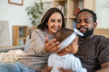 African family happy play at home, loving father holding and playing with baby while mother watches with joy, happy parenting moment full of love, affection, care and connection in cozy family at home