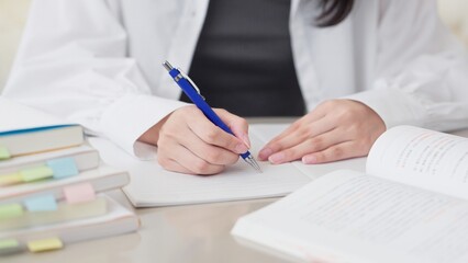 参考書で勉強をするアジア人女性