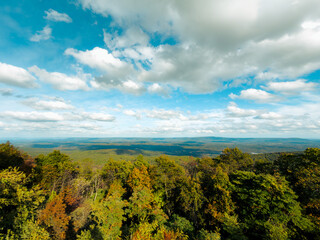 Fototapeta premium A beautiful mountain overlook view during the day with colorful autumn and fall colors. Blue sky and white clouds. 