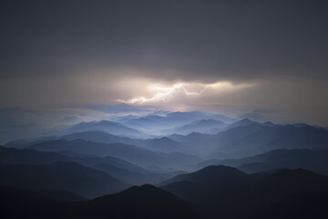 Dramatic lightning striking distant mountain under dark storm clouds atmospheric landscape moody blue tones nature power evening wilderness electric energy scenic view