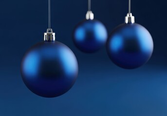 Elegant blue Christmas ornaments hanging against a dark blue background