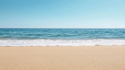 Obraz premium Calm beach scene with soft horizon, clear blue sky, and gentle waves lapping at shore