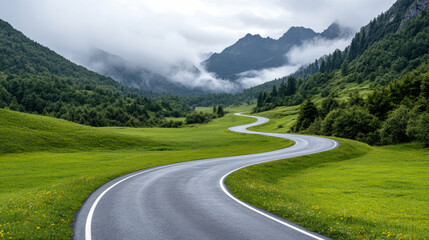 Winding road through lush green hills and misty mountains creates serene journey