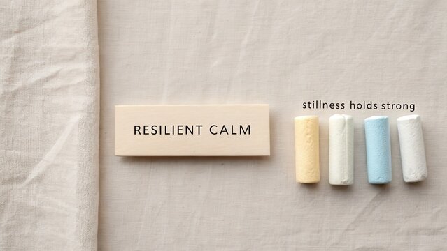 Inspirational visual with text "Resilient Calm" and colored chalk on a soft beige cloth conveying tranquility and inner strength