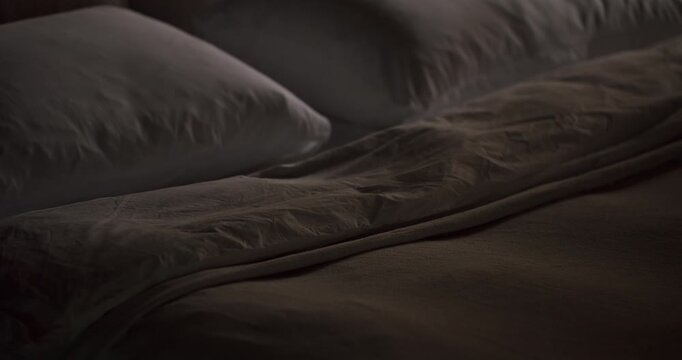 An intimate and detailed close-up of a neatly arranged bed with plush pillows and silky sheets, evoking a sense of calm and comfort in a subdued color palette. Comfortable Bed with Soft Pillows