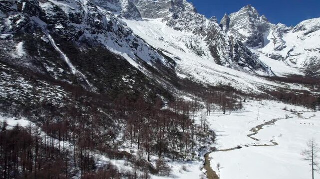 Drone view of snow covered mountains and forests in Bipeng Valley in Sichuan, China in sunny winter day, high angle view of beautiful winter landscape. 4k real time footage, travel concept.