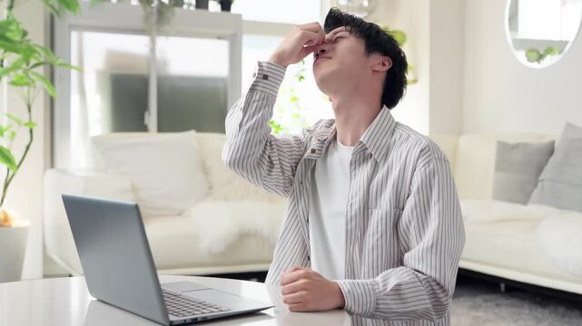 パソコン作業で目が痛くなるアジア人男性