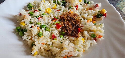 Colorful Spanish rice dish with mixed vegetables and spices served on a white plate, capturing a...