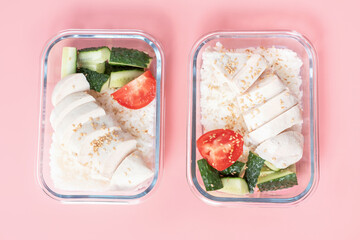 Two glass boxes with rice, chicken fillet and vegetables on pink background, top view, meal planning concept.
