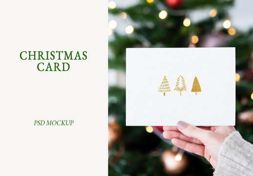 Woman Holding A Christmas Card In Front Of A Christmas Tree Mockup