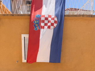 large Croatian flag hanging on side of building facade outdoors in Croatia
