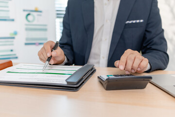 A businessman in a suit analyzing financial charts and performance reports in a bright modern office, focusing on strategy, data, and budget planning for company growth and long-term success.