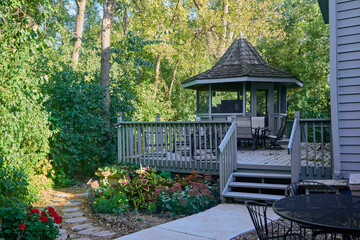 Porch and gazebo in my backyard with a flower garden and surrounded by forest