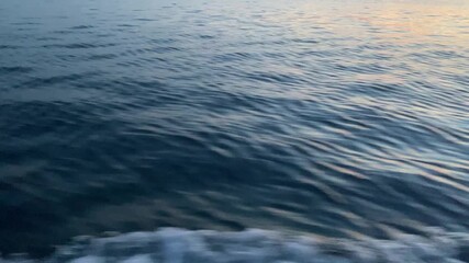 Rippling ocean surface with shades of blue and hints of sunlight reflecting on the water.