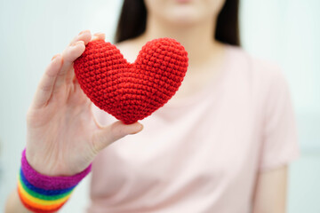 Fototapeta premium Asian woman holding LGBT heart with rainbow flag.