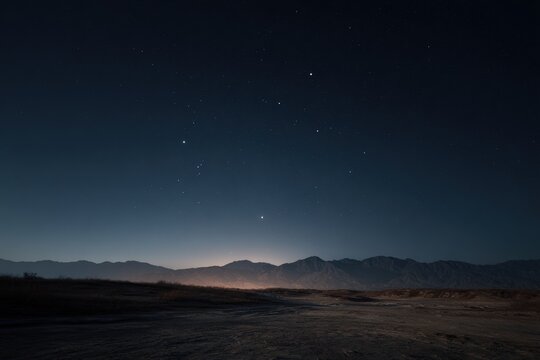Night desert landscape with distant mountains and stars