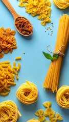 A collection of various dried pasta shapes on a light blue surface