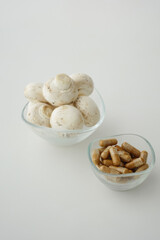 Fresh mushrooms and dietary supplements on a white surface