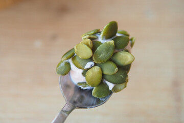 Tasty spoonful of yogurt topped with pumpkin seeds