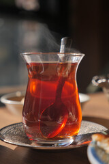 Steaming cup of turkish tea on a wooden table in a cozy cafe