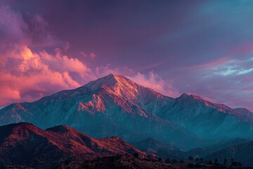 Majestic mountain range under a colorful, vibrant sky at dusk with pink clouds. Use this image for travel, adventure, or landscape photography themes.