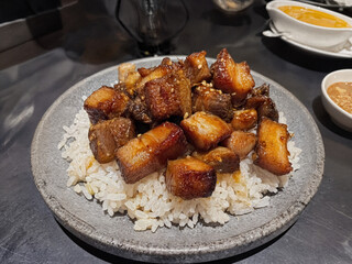 A popular Filipino dish featuring succulent, caramelized pork belly chunks served over fragrant garlic rice, creating a perfect blend of savory and slightly sweet flavors.