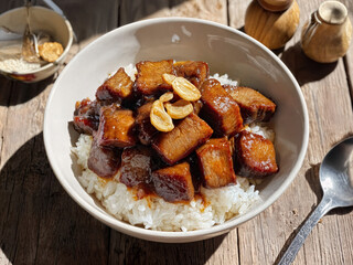 An appetizing dish with boiled rice, juicy chopped square meat and fresh garlic. Asian cuisine in an exquisite presentation.