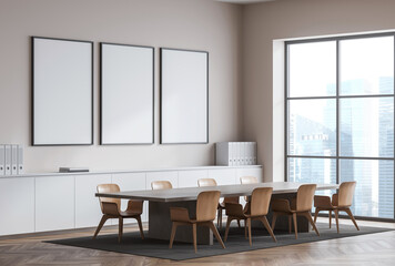 Contemporary office interior featuring three empty vertical posters on a clean wall above a white cabinet, with wooden chairs and large windows. 3D Rendering