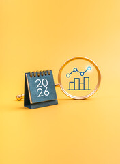 Business growth and data analysis concept for 2026 with blue desk calendar and magnifying glass highlighting bar chart. Ideal for new year trends, planning, forecasting, and performance strategy.