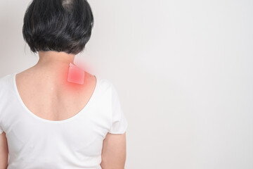 Elderly Woman having Shoulder Pain with Medicated pain relief patch plaster for Muscle Inflammation...