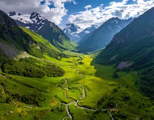 Aerial view of a lush green valley with winding river and snowy mountains