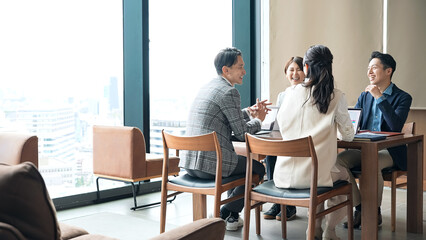 オフィスで会議するカジュアルなビジネスパーソンのグループ