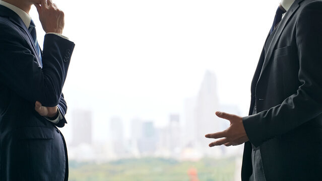 A group of business people having a conversation with a city in the background