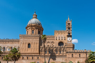Obraz premium Historic cathedral in Sicily with palm trees and clear blue sky