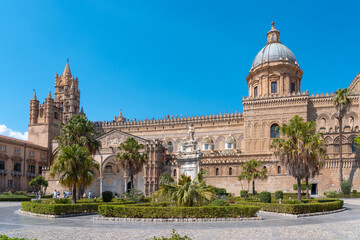 Obraz premium Historic cathedral in Sicily with palm trees and clear blue sky