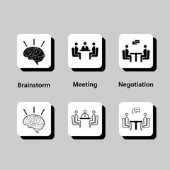 A group of people sitting around a table, with some of them holding a pen