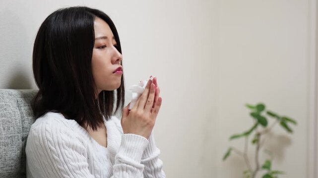 Closeup of a woman blowing her nose with a tissue