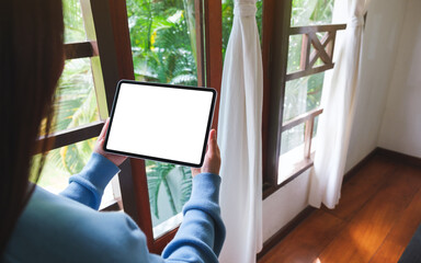 Mockup image of a woman holding tablet with blank desktop white screen at home