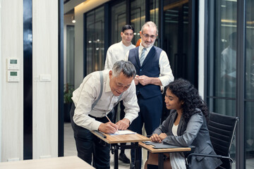 Business people checking in at conference registration table. International diverse corporate business partnership concept.