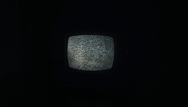 Displaying CRT television showing multicolored static mosaic pattern in dim room, dark backdrop - Powered by Adobe