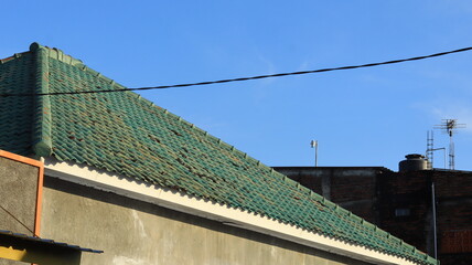 The roof of a building is made of green tiles.